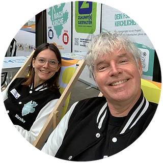 Bastian Basse - Grinsender Mann mit Brille, Bart und Basecap