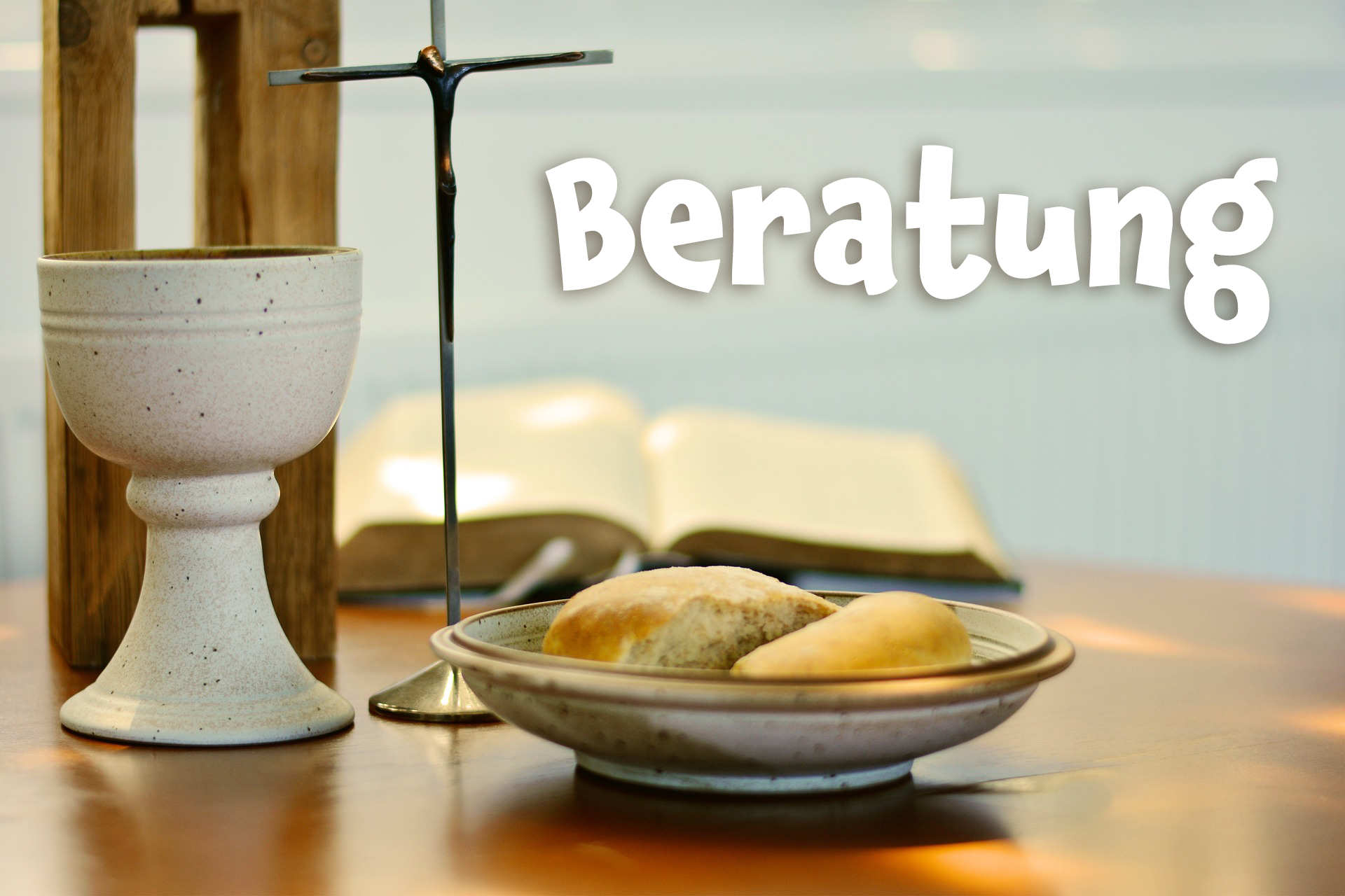 Kasten mit dem Schriftzug Beratung. Auf dem Foto ist ein Auschnitt eines Holzaltars zu sehen, auf dem ein dünnes Metallkreuz mit Korpus steht, dazu ein grauer Abendmahlskelch und ein grauer Teller mit zwei Weizenbrothälften.