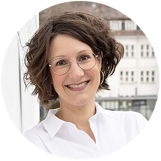 Bastian Basse - Grinsender Mann mit Brille, Bart und Basecap